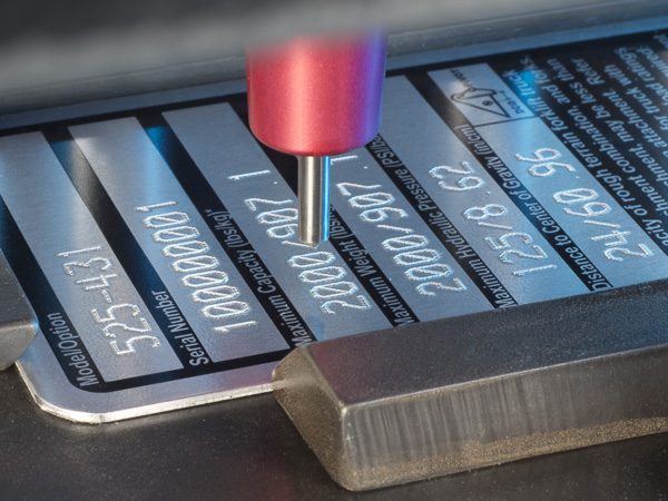 dot peen stamping machine engraving characters on a metal nameplate