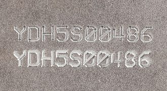 text deep stamped into rough metal part surface