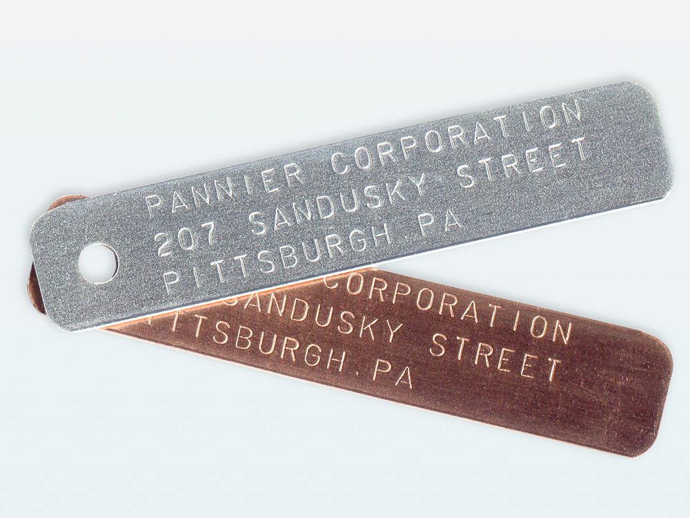 aluminum and brass name tags stamped with text